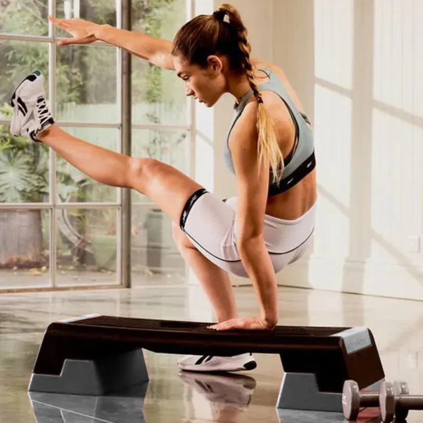 Woman exercising on a step machine in a home setting