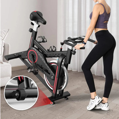 Woman using a stationary bike in a home setting with a close-up of the bike's wheel.