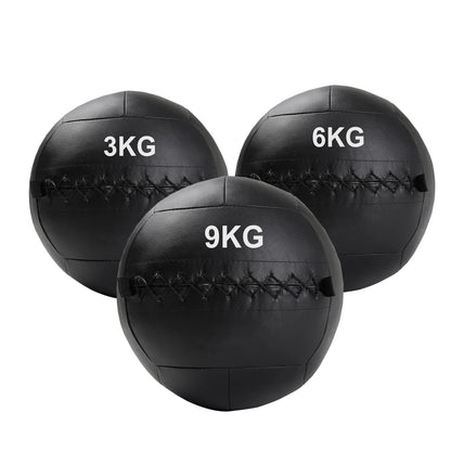 Three black wall balls with weight markings on a white background